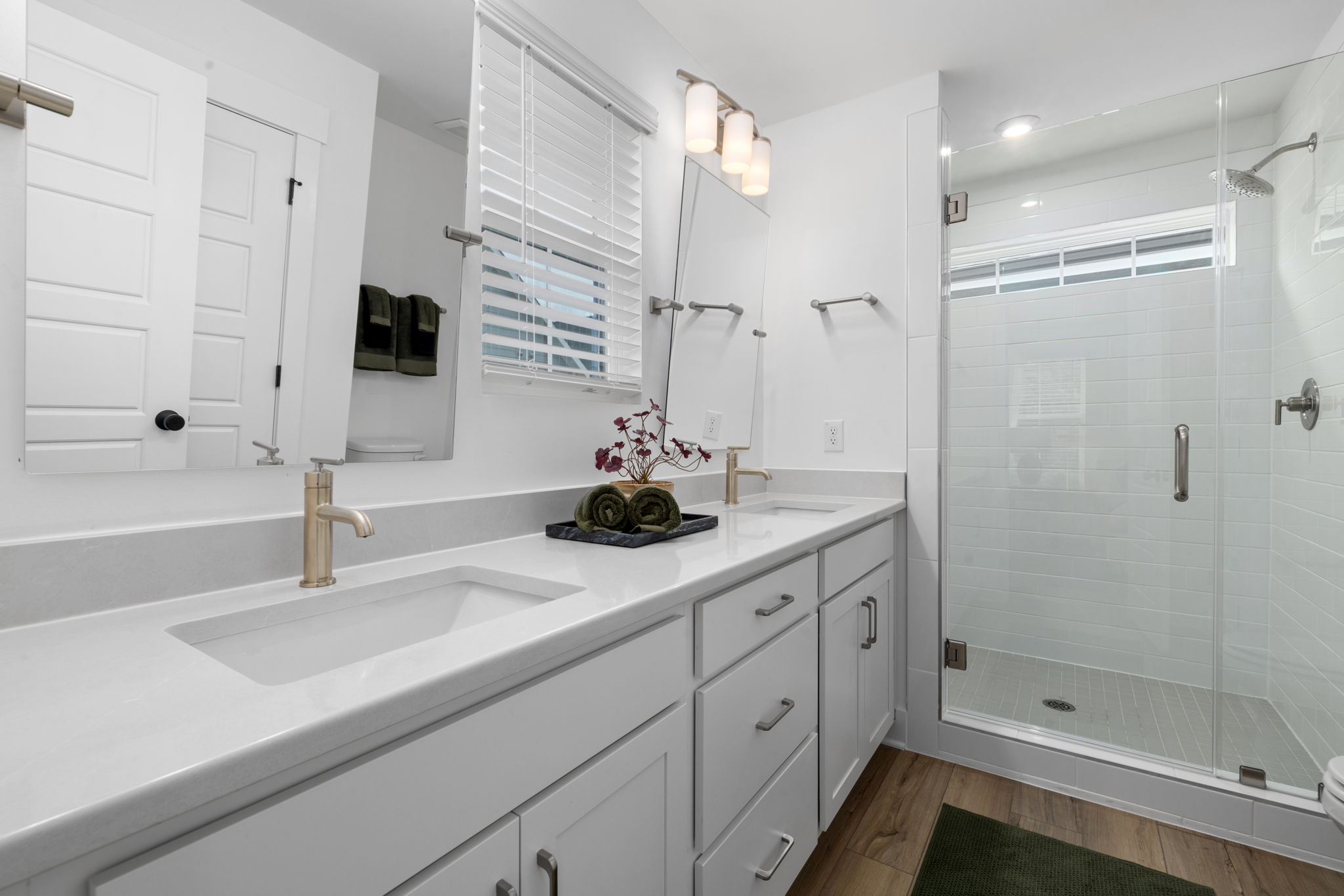 Bath with double vanities and frameless glass shower